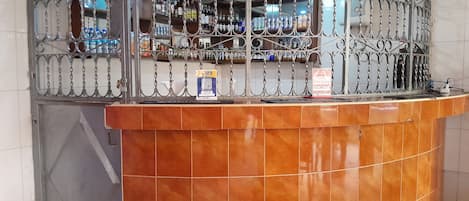 A reception desk with a metal decorative partition, a tiled wall, and a door.
