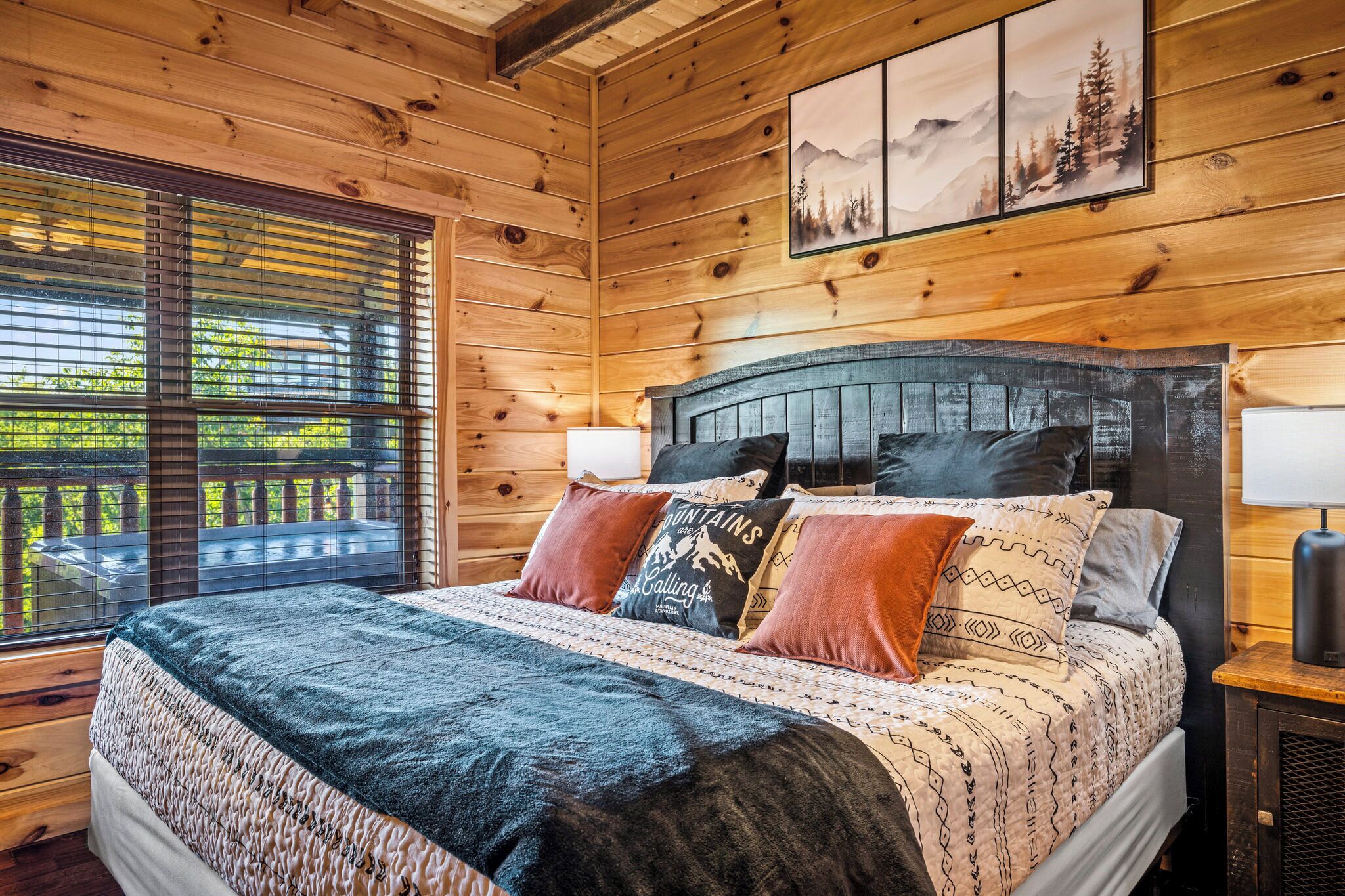 Un dormitorio de cabaña de madera con una cama, almohadas y una mesita de noche.