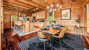 L’intérieur d’un chalet en bois comprend un coin repas, une cuisine et un bar.