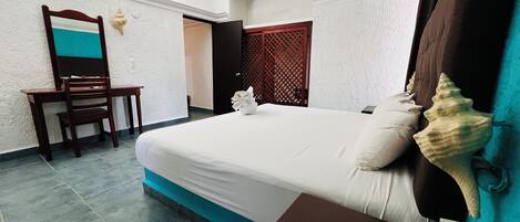 Una habitación de hotel con una cama, un escritorio y una silla.