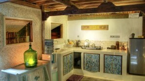 A kitchen with a tiled backsplash, a sink, a stove, and a refrigerator. - Villas Samalama Gili Trawangan (Gili Trawangan)