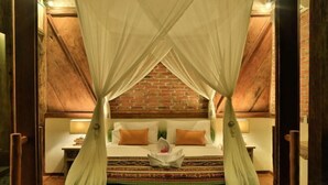 A room with a bed, a brick wall, and a wooden ceiling. - Villas Samalama Gili Trawangan (Gili Trawangan)