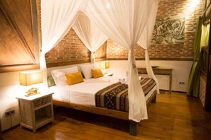Una habitación con cama con dosel, mesita de noche y lámpara de pared.