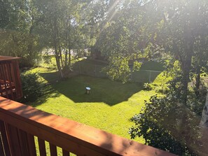A backyard with a lawn, a metal object, and a wooden deck. - Entire Home: Westchester Lagoon (Anchorage)