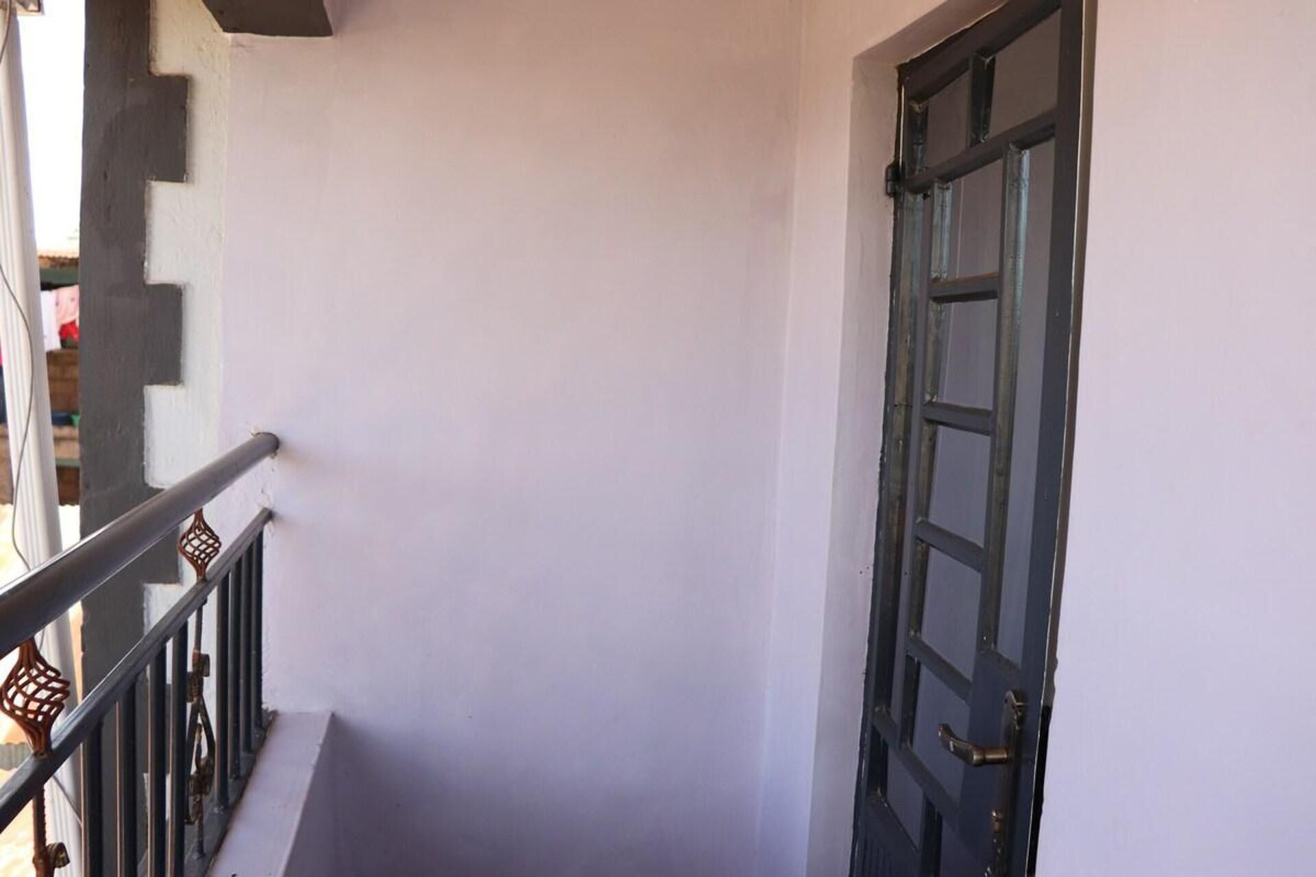 A staircase with a metal railing and a door with a glass panel.