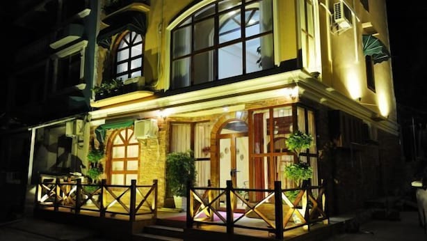 A two-story building with a balcony, large windows, and a wooden fence. - Laimi Theme Inn (Zhangjiajie)