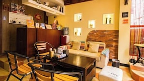 A cozy hotel lobby with a wooden reception desk, a sofa, and a coffee table. - Laimi Theme Inn (Zhangjiajie)
