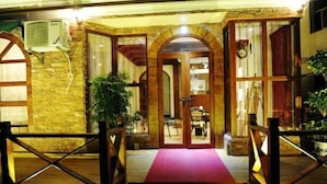 A hotel entrance with a red carpet, wooden gates, and a stone facade. - Laimi Theme Inn (Zhangjiajie)