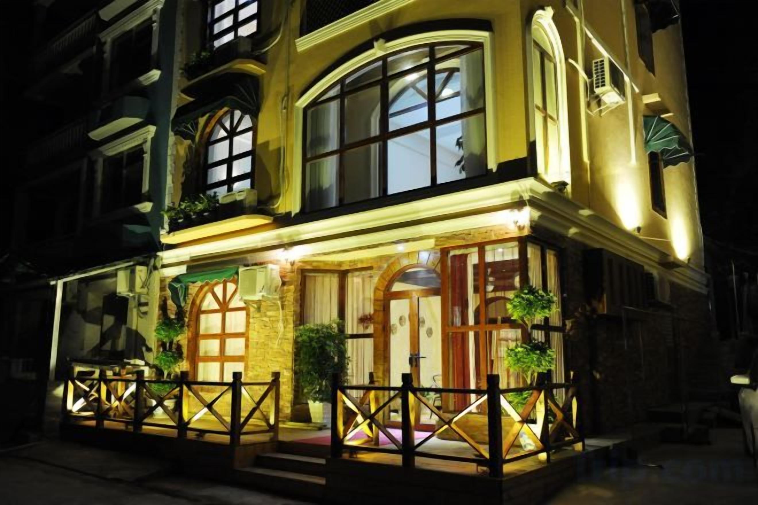 A building with a prominent entrance, large windows, and a balcony with railings.