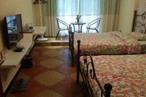 Une chambre d’hôtel avec deux lits, une télévision, une petite table et une chaise.