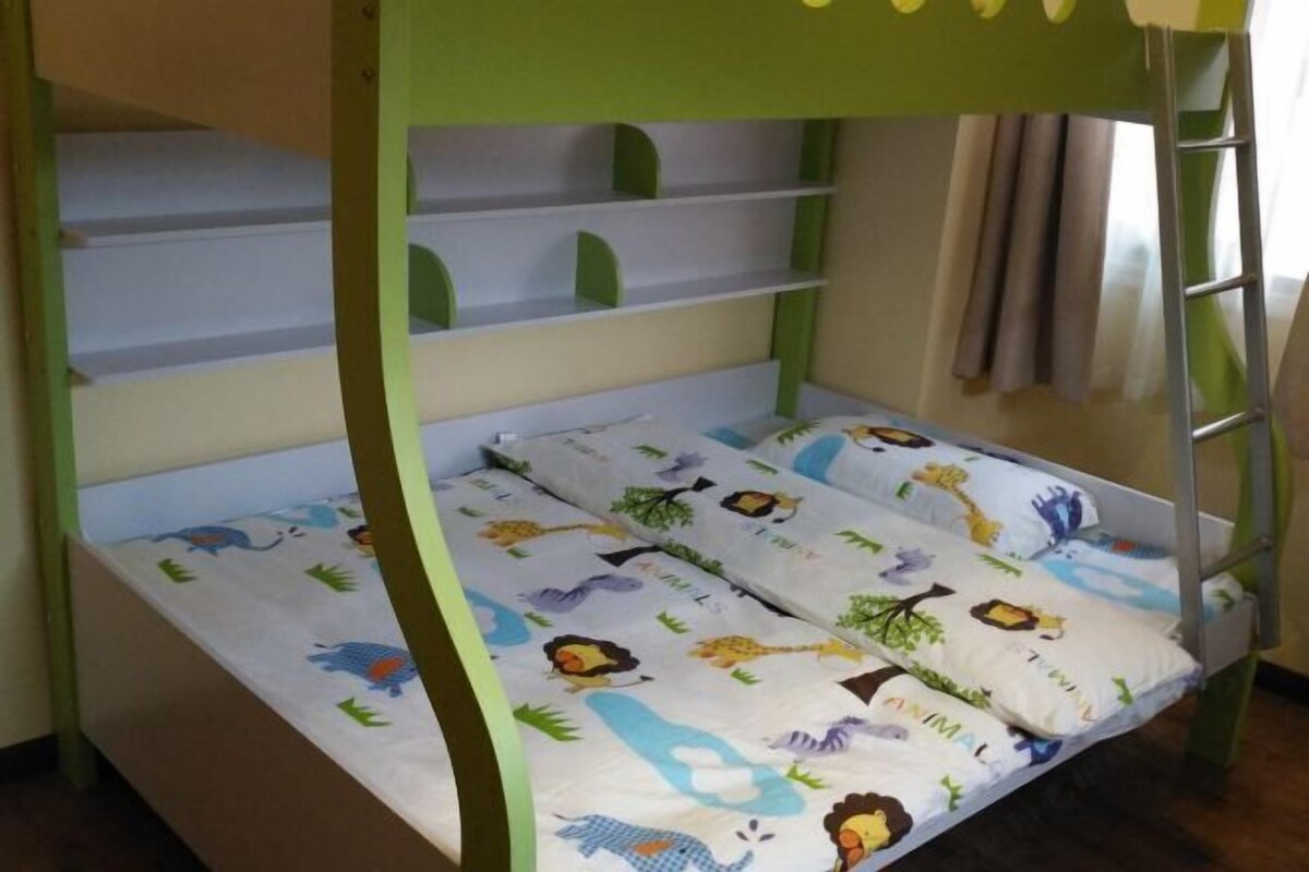A bunk bed with a green frame and a mattress featuring animal prints.