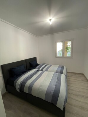 A bedroom with a bed, a window, and a ceiling light. - Maison à la Hauteur d un Beau Village (Apt)