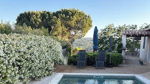 A rectangular swimming pool with a wooden deck and lounge chairs. - Maison à la Hauteur d un Beau Village (Apt)