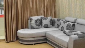 A room with a large sectional sofa, a glass ceiling, and a view of the outdoors. - Liyang Hot Spring Garden Hotel (Liyang)