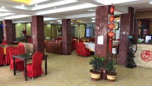 A spacious restaurant with red chairs and tables, marble pillars, and potted plants. - Liyang Hot Spring Garden Hotel (Liyang)