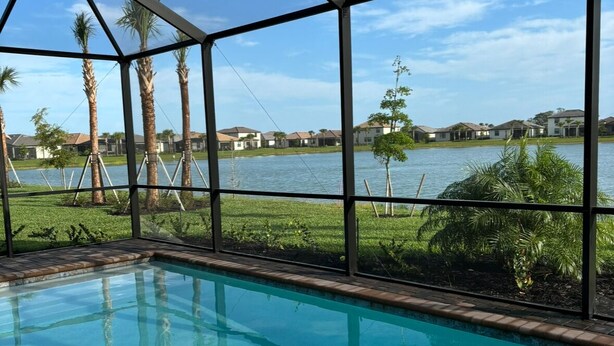 A swimming pool with a view of a lake and houses in the background.