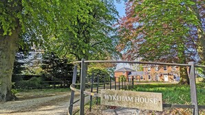 A sign for Wykeham House with a gravel path and trees in the background. - 1 bedroom accommodation in Wykenham, near Spalding (Wykenham, near Spalding)