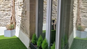 Un bâtiment moderne avec une façade en pierre, une entrée en verre et des plantes en pot.