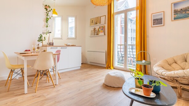 A modern living room with a dining area, a sofa, and a table with potted plants. - L'Atypique - Appt à 150m de la plage (Arcachon)