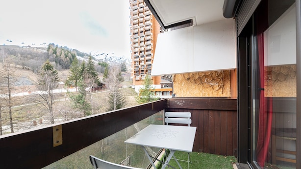 A balcony with a table and chairs, overlooking a mountainous area with a ski lift in the background. - Le Corbier - Studio avec belle vue montagne (Villarembert)