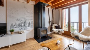 Una sala de estar moderna con una estufa de leña, un ventanal grande y un esquí.