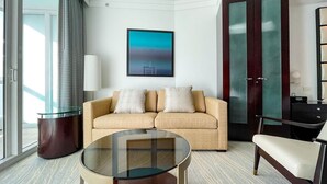 A modern hotel room with a beige sofa, a glass coffee table, a dark wooden cabinet, and a large window with curtains. - FontaineBleau Balcony 10 min from SoBe (Miami Beach)