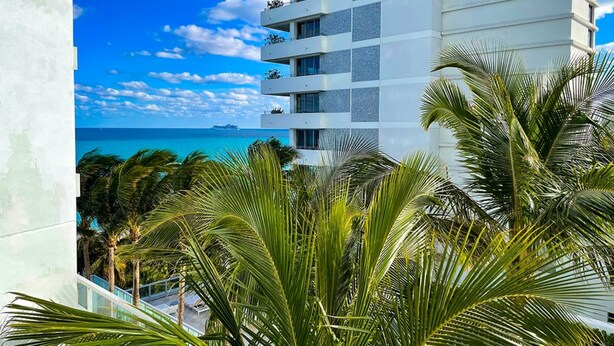 A modern building with multiple balconies overlooking a clear blue sea. - FontaineBleau Balcony 10 min from SoBe (Miami Beach)