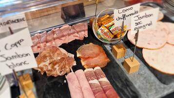 A deli counter with various types of cured meats displayed, including labels for each type.
