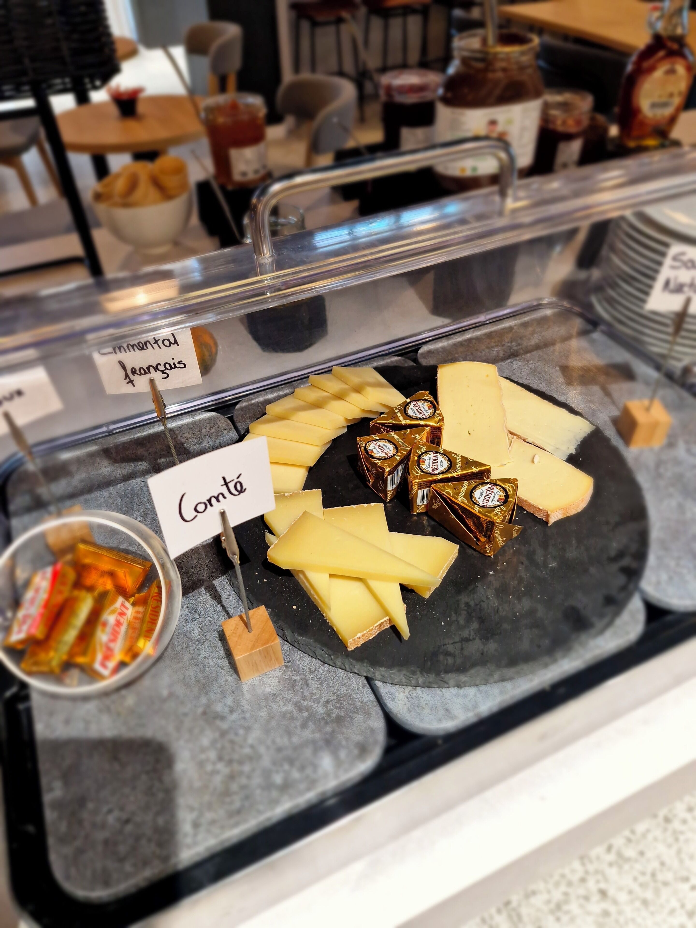 A cheese display with labels for Comté and Emmental.