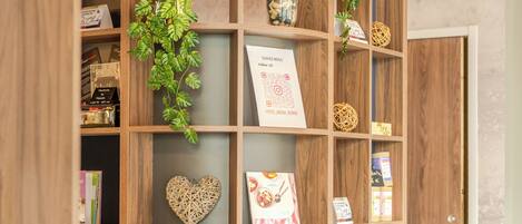 Une bibliothèque en bois contenant divers objets, notamment des livres, un décor en forme de cœur et de petites plantes.