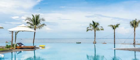 Alberca al aire libre, sombrillas en la alberca y camastros