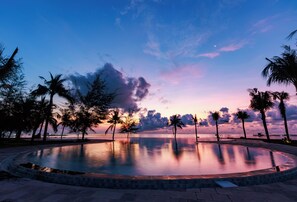 Una piscina al aire libre, sombrillas, tumbonas