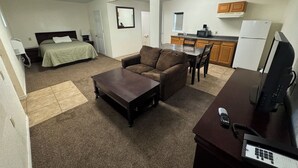 A compact living space with a bedroom, kitchenette, and a seating area. - Oriental Hotel (Canadian)