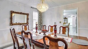 A dining room with a chandelier, ornate mirror, and wooden chairs. - Masters Retreat! quite, great location 4BDR House (Augusta)