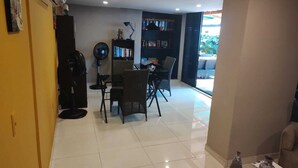 A dining area with a table and chairs, a bookshelf, and a fan. - Hermosa Casa Completa Tipo Hotel Boutique - Cartagena - Castillogrande (Cartagena de Indias)