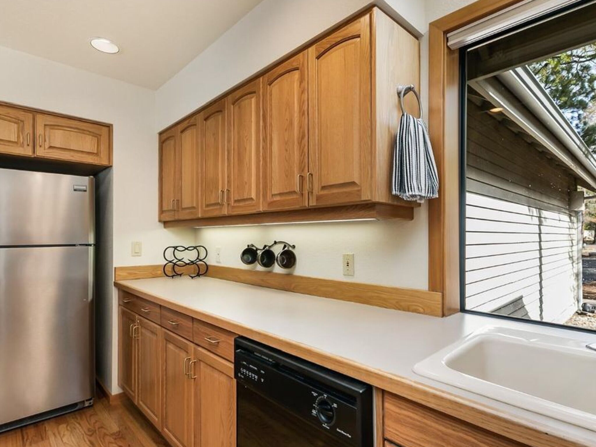 A modern kitchen with wooden cabinets, stainless steel appliances, and a dishwasher.