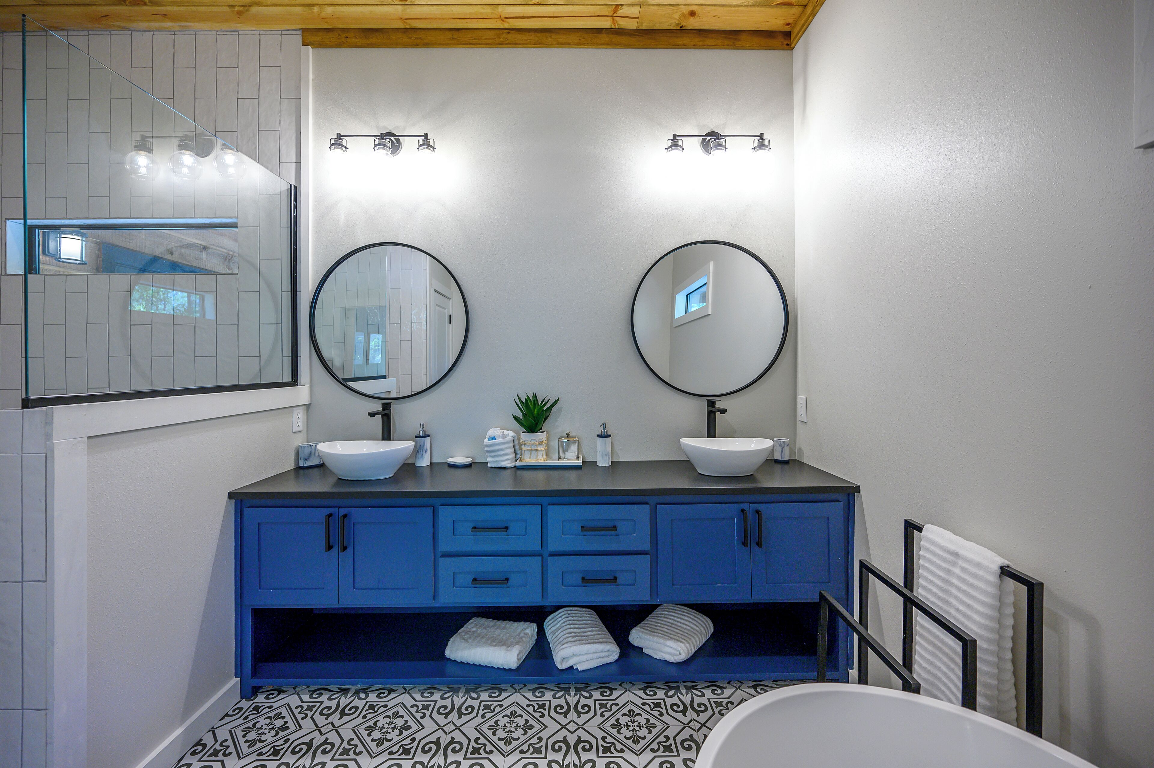 Une salle de bain avec deux lavabos, un miroir et une douche.
