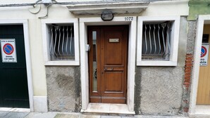 A building with a wooden door, numbered 1072, and barred windows. - Casa Venturini by Ca-sa Check (Chioggia)