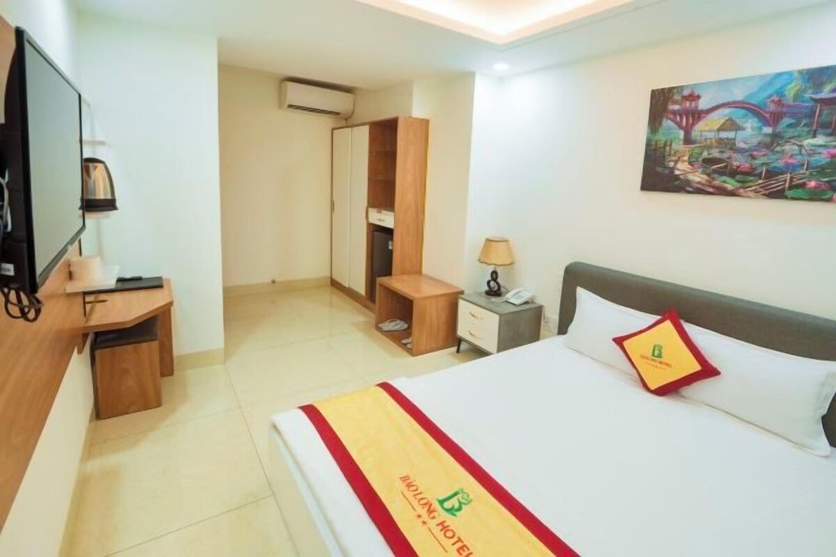 Une chambre d’hôtel avec un lit, une table de chevet, une lampe et un tableau au mur.