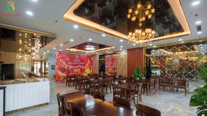 A spacious restaurant with marble flooring, wooden tables and chairs, and a chandelier. - Bao Long Go Vap Hotel (Ho Chi Minh City)