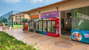 A row of ice cream vending machines outside a building with a sign for 'TUBORG' and a large advertisement for 'Nestle'.