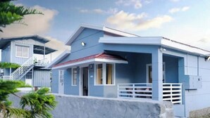 A two-story building with a blue exterior and a white balcony.