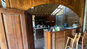 Una cocina rústica con armarios de madera, pared de ladrillo y encimera de piedra.