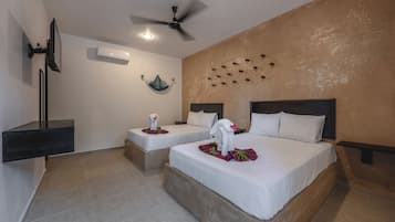 A hotel room with two beds, a ceiling fan, an air conditioning unit, and a wall-mounted shelf.