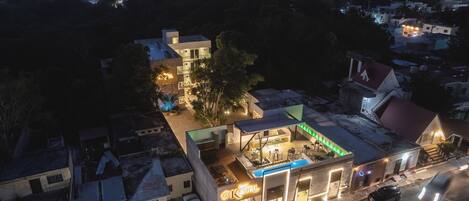 A hotel with a rooftop bar, outdoor seating, and a swimming pool.