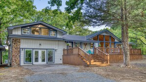 A two-story house with a stone foundation, large windows, and a wooden deck. - Tenkiller Lake Private Pickleball Court
Sleeps 20
Shuffleboard Pool Table
13Beds (Cookson)