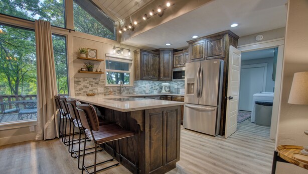 A modern kitchen with a large island, bar stools, and a view of the outdoors. - Tenkiller Lake Private Pickleball Court
Sleeps 20
Shuffleboard Pool Table
13Beds (Cookson)