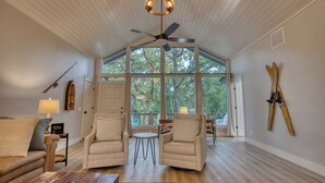 A spacious room with a high ceiling, a ceiling fan, and large windows offering a view of trees. There are two armchairs, a small table, and a sofa. - Tenkiller Lake Private Pickleball Court
Sleeps 20
Shuffleboard Pool Table
13Beds (Cookson)