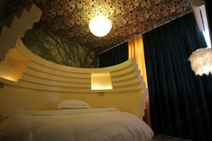 A bedroom with a curved ceiling, a bed, and a wall-mounted light fixture. - Miss Inn (Zhangjiajie Forest Park Biaozhimen) (Zhangjiajie)