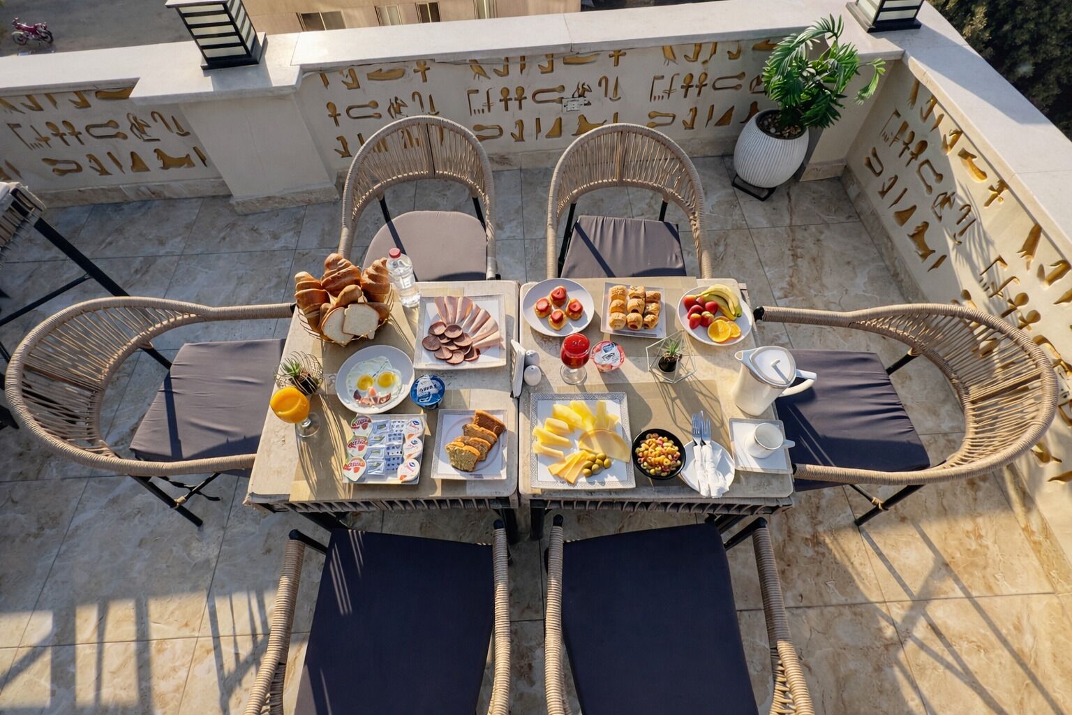 Ein Esstisch mit verschiedenen Frühstücksangeboten und Korbstühlen.